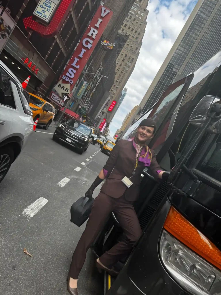 Letuška Kaja v uniforme Etihad Airways stojí na Times Square v New Yorku a usmieva sa.